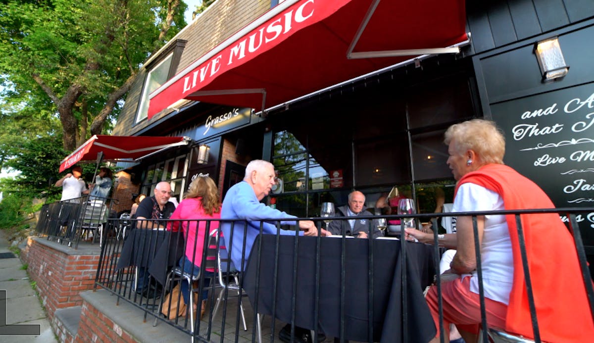 a group of people standing outside of a restaurant